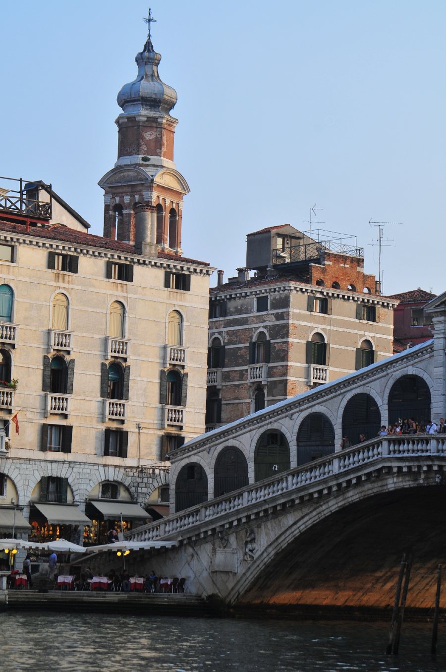 Ponte ad arco in pietra su un canale tra edifici storici di Venezia